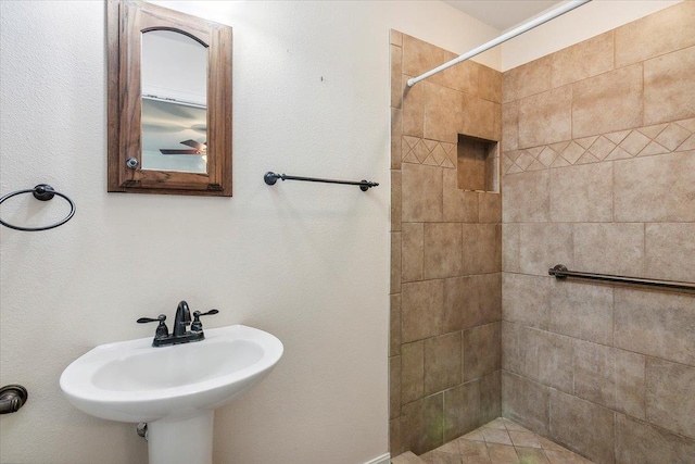 bathroom featuring a tile shower and sink