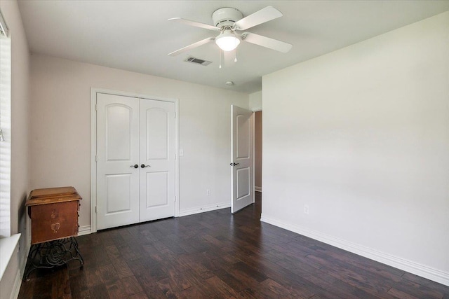 unfurnished bedroom featuring dark hardwood / wood-style flooring, a closet, and ceiling fan