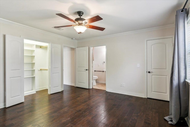 unfurnished bedroom featuring ensuite bathroom, a spacious closet, ceiling fan, and crown molding