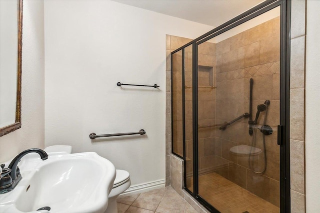 bathroom with sink, tile patterned flooring, a shower with shower door, and toilet