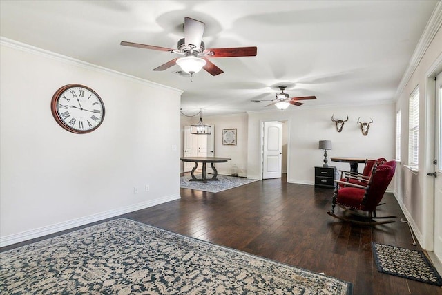 living area with ceiling fan with notable chandelier, crown molding, and dark wood-type flooring