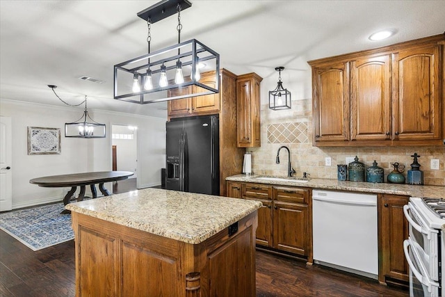 kitchen with white appliances, sink, decorative light fixtures, a chandelier, and a center island