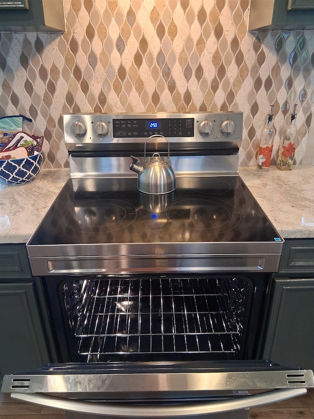 5330 Landry Ln, Beaumont, TX 77708 - kitchen view of electric range, decorative backsplash, and light stone counters