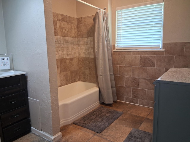 5330 Landry Ln, Beaumont, TX 77708 - full bathroom featuring vanity, shower / bathtub combination with curtain, and tile walls