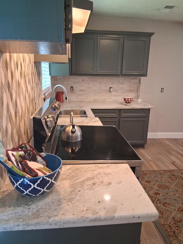5330 Landry Ln, Beaumont, TX 77708 - kitchen with a sink, light wood finished floors, tasteful backsplash, baseboards, and light stone countertops