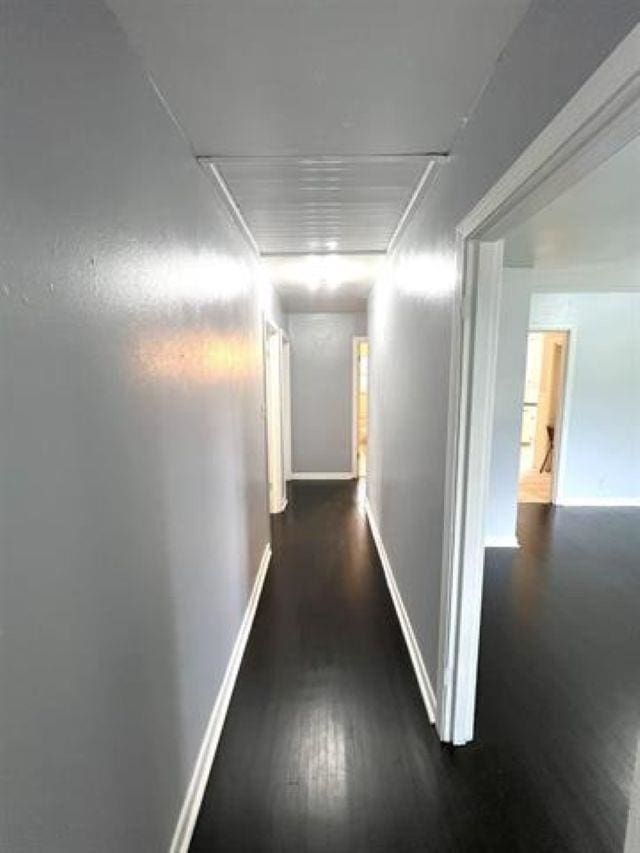 hallway with wood finished floors and baseboards