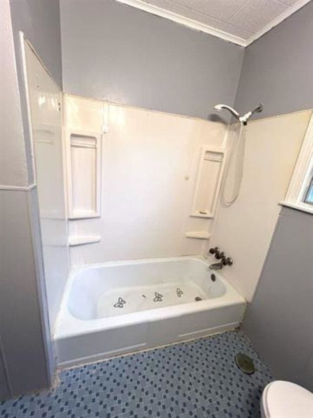 bathroom featuring bathtub / shower combination and toilet