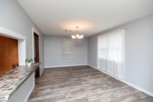 410 Creekwood St, Vidor, TX 77662 - unfurnished dining area featuring a chandelier, wood finished floors, and baseboards