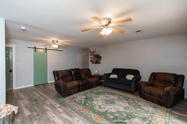 410 Creekwood St, Vidor, TX 77662 - living room featuring a barn door, ceiling fan, wood finished floors, and baseboards