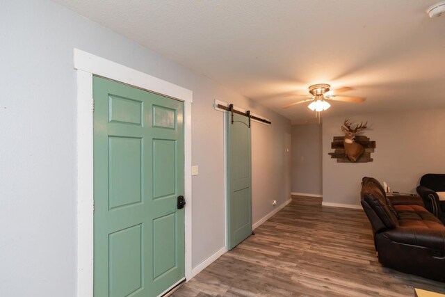 410 Creekwood St, Vidor, TX 77662 - entryway featuring a barn door, a ceiling fan, baseboards, and wood finished floors