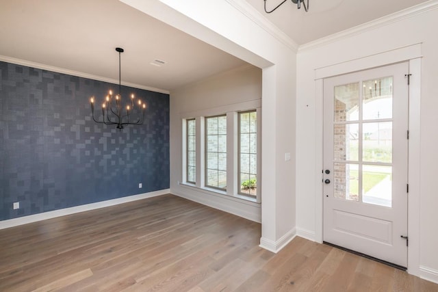 foyer featuring crown molding, hardwood / wood-style floors, and a chandelier