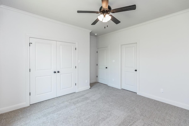 unfurnished bedroom with crown molding, light carpet, ceiling fan, and a closet