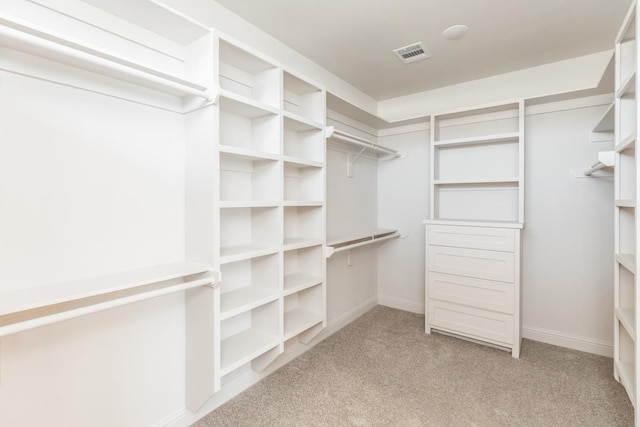 walk in closet featuring light colored carpet