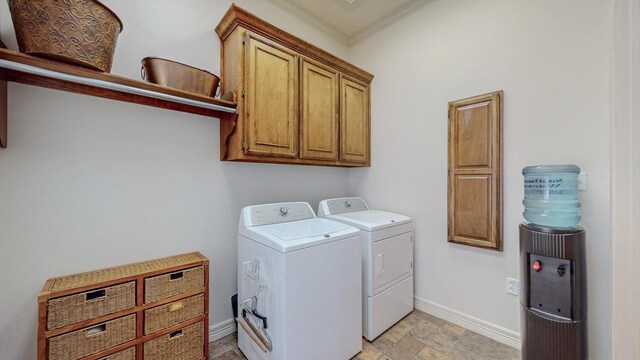 clothes washing area with washer and clothes dryer, cabinet space, ornamental molding, baseboards, and light stone finish flooring