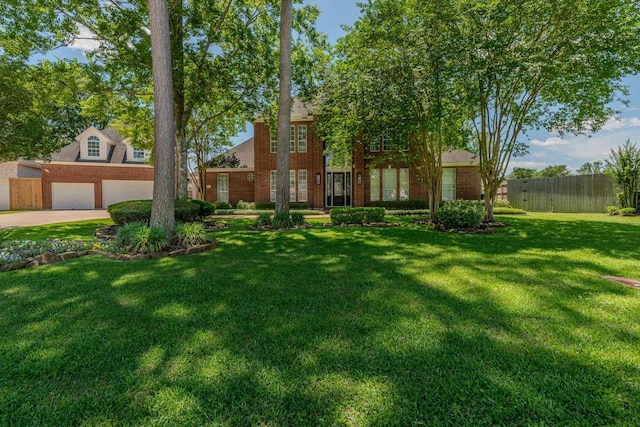 view of front of house with concrete driveway, brick siding, a front lawn, and fence