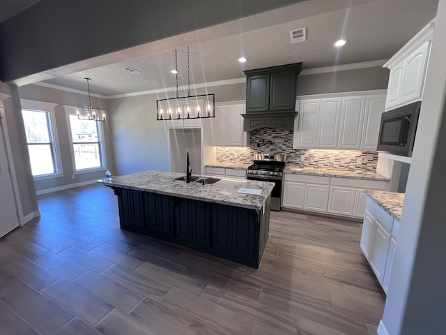 kitchen featuring stainless steel stove, white cabinets, a sink, and a center island with sink