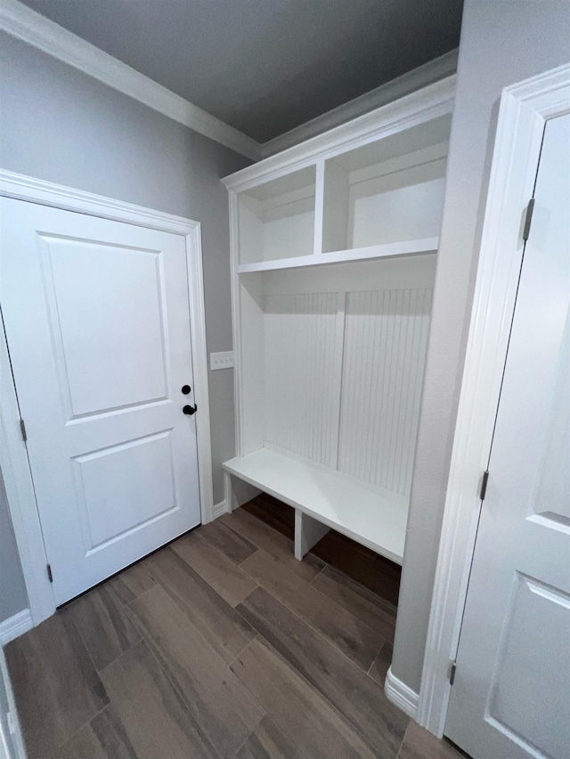 mudroom featuring dark wood-style floors and crown molding