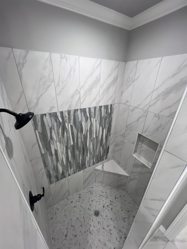 full bathroom with marble finish floor, tiled shower, and crown molding