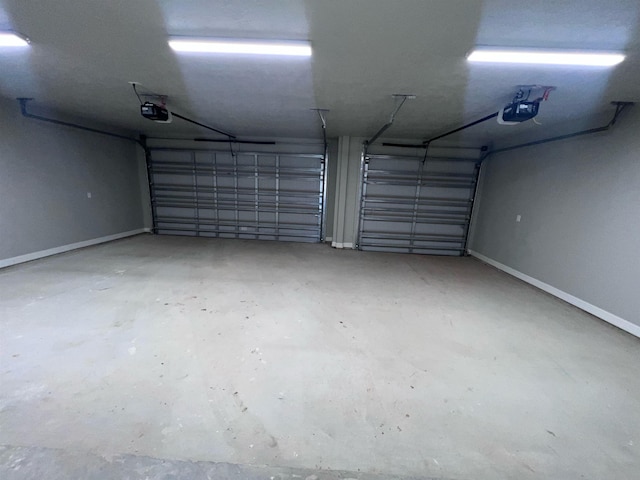 garage featuring a garage door opener and baseboards