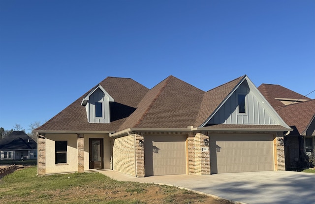 view of front facade with driveway, brick siding, roof with shingles, and an attached garage