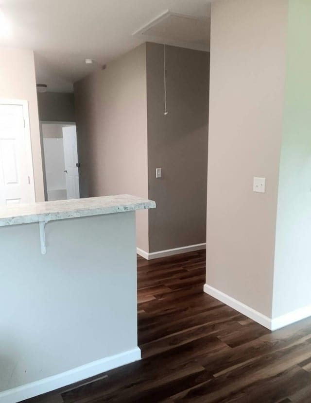 kitchen featuring a breakfast bar, dark hardwood / wood-style floors, and kitchen peninsula