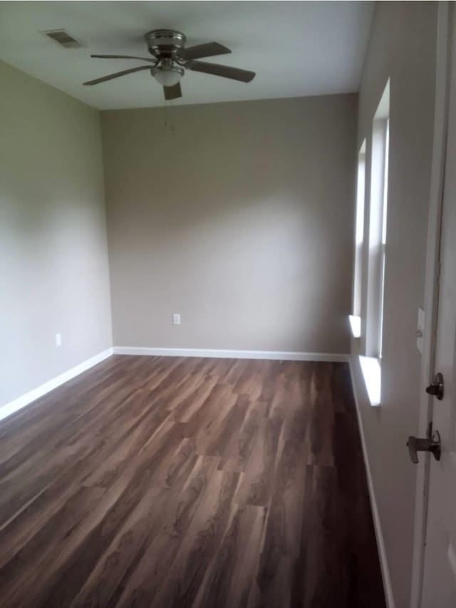 spare room featuring ceiling fan and dark hardwood / wood-style flooring