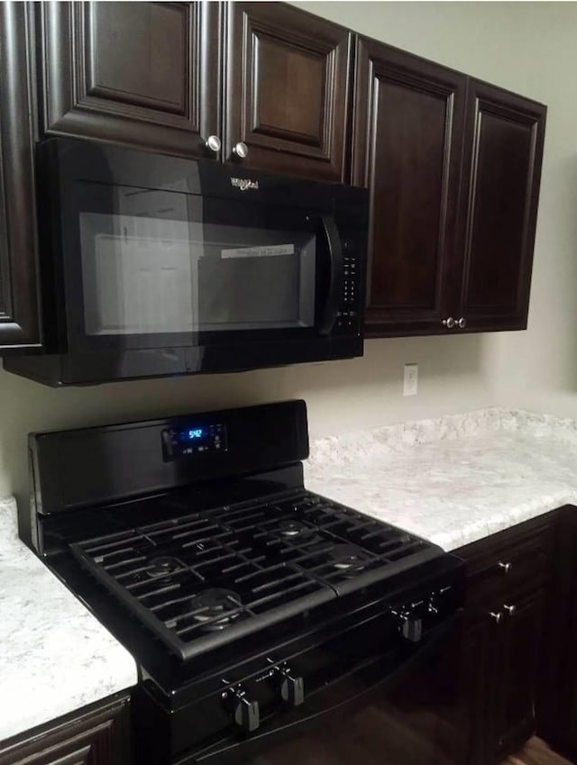 kitchen featuring dark brown cabinetry and black appliances