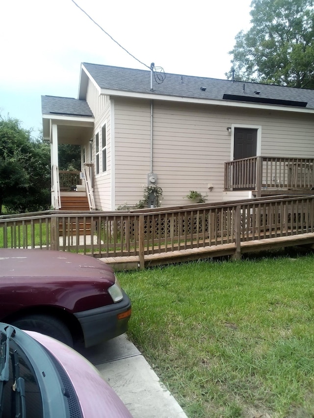 rear view of property featuring a yard and a deck