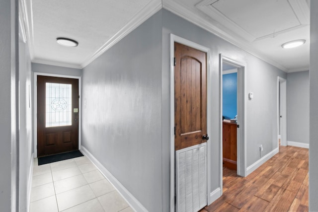 entryway with crown molding, baseboards, and visible vents