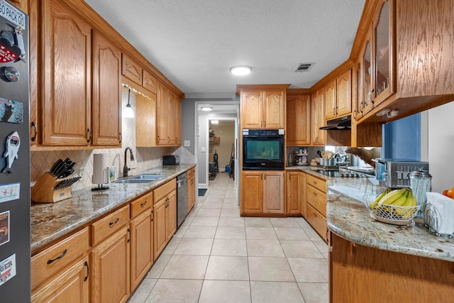 kitchen with light stone counters, visible vents, a sink, black appliances, and under cabinet range hood