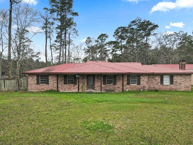 ranch-style home featuring a front lawn, metal roof, fence, and a chimney