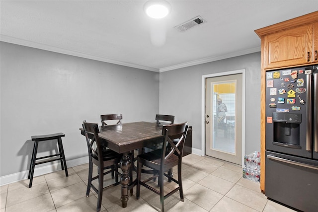 dining room with crown molding, light tile patterned floors, baseboards, and visible vents