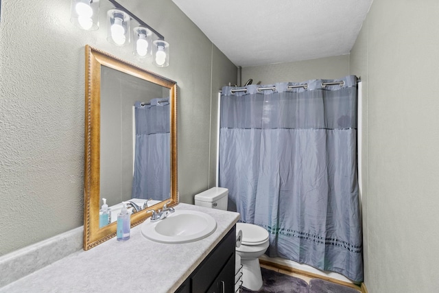 bathroom with toilet, vanity, a shower with curtain, and a textured wall