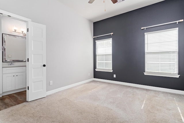 4450 W Brown St, Orange, TX 77630 - unfurnished bedroom with carpet floors, ensuite bath, a sink, baseboards, and a ceiling fan