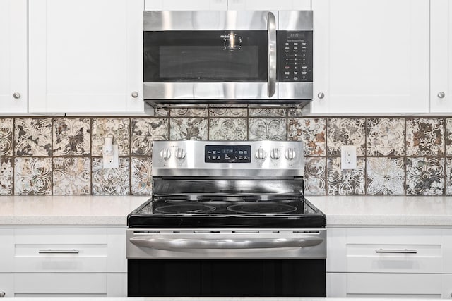 4450 W Brown St, Orange, TX 77630 - kitchen featuring appliances with stainless steel finishes, tasteful backsplash, white cabinetry, and light stone counters