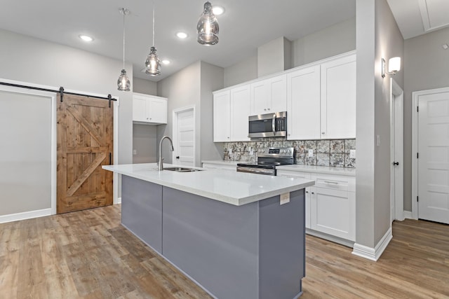 4450 W Brown St, Orange, TX 77630 - kitchen with stainless steel appliances, a sink, light wood-style flooring, backsplash, and white cabinetry