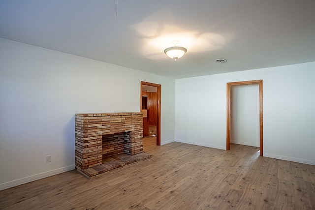 unfurnished living room featuring a fireplace and light hardwood / wood-style flooring