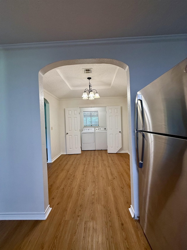 175 Princeton Pl, Vidor, TX 77662 - unfurnished dining area featuring a raised ceiling, arched walkways, wood finished floors, baseboards, and ornamental molding