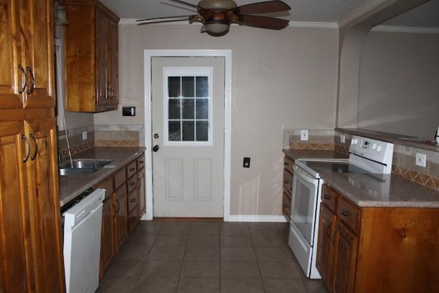 kitchen with white appliances, sink, ceiling fan, dark tile patterned floors, and ornamental molding