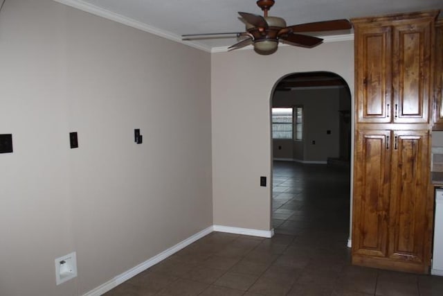 unfurnished room featuring dark tile patterned floors, ceiling fan, and crown molding