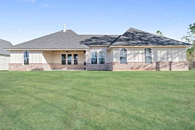 view of front of house with a front lawn, brick siding, and ceiling fan