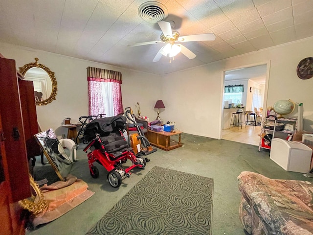 carpeted living room featuring visible vents and a ceiling fan