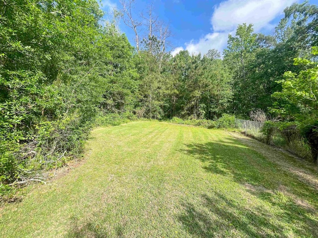 view of yard featuring a view of trees and fence