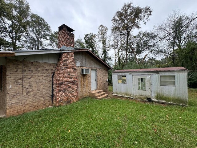 1506 Hopkins, Jasper, TX 75951 - rear view of house featuring a chimney, a yard, brick siding, entry steps, and a wall mounted AC