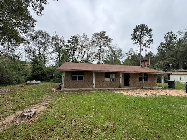 rear view of property with a chimney and a lawn