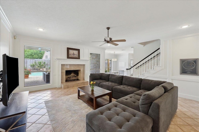 4820 Ashland St, Beaumont, TX 77706 - living room with light tile patterned floors, a ceiling fan, stairs, a fireplace, and ornamental molding