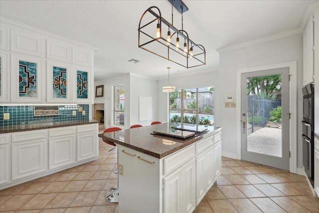 4820 Ashland St, Beaumont, TX 77706 - kitchen featuring decorative backsplash, black appliances, white cabinetry, and light tile patterned floors