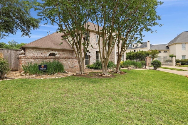 4820 Ashland St, Beaumont, TX 77706 - view of front of home featuring brick siding, fence, and a front yard