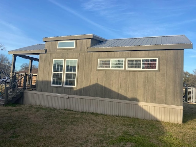 view of home's exterior with a yard and central AC unit