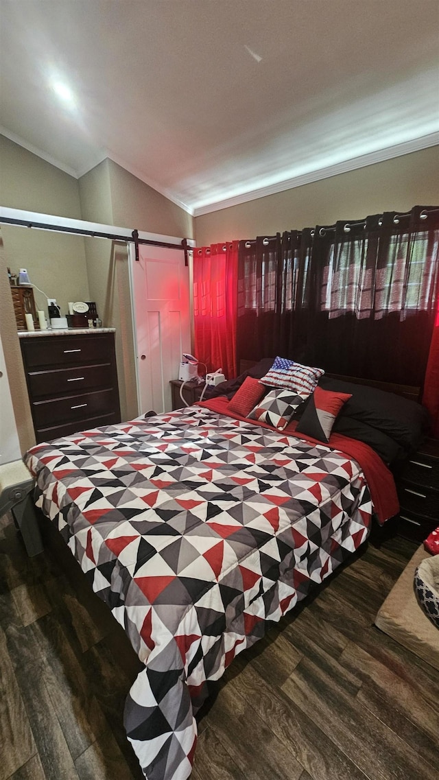 bedroom with wood-type flooring, a barn door, lofted ceiling, and crown molding